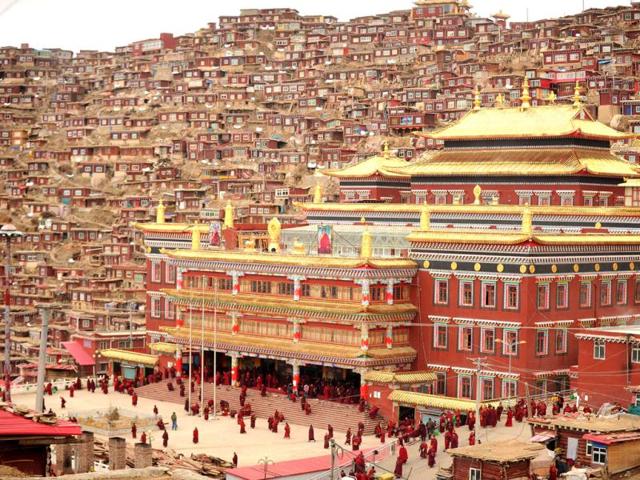 Buddhist nuns and monks walk through Seda Monastery, the largest Tibetan Buddhist school in the world, with up to 40,000 monks and nuns in residence for some parts of the year. (AFP)