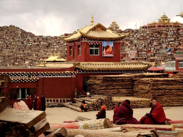 Buddhist monks sit on logs chatting, in Seda Monastery, the largest Tibetan Buddhist school in the world, with up to 40,000 monks and nuns in residence for some parts of the year.(AFP)