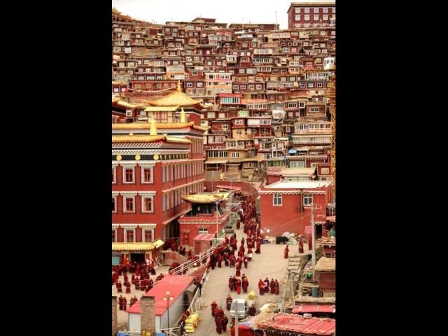 Buddhist nuns and monks walking through Seda Monastery, the largest Tibetan Buddhist school in the world, with up to 40,000 monks and nuns in residence for some parts of the year. (AFP)