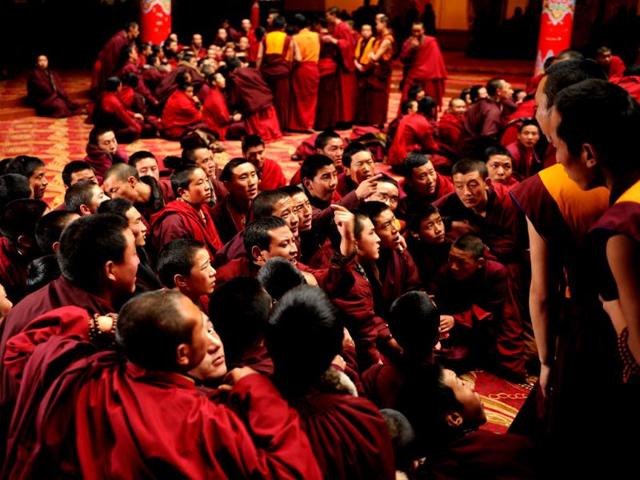 Apprentice Buddhist monks debate in Seda Monastery, the largest Tibetan Buddhist school in the world, with up to 40,000 monks and nuns in residence for some parts of the year. (AFP)