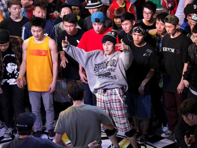 People watch as a dancer performs during the 2013 B-BOY Shanghai breakdancing competition in Shanghai. Reuters