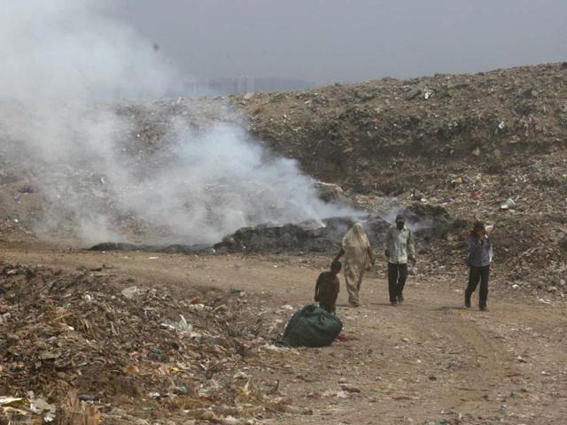 Workers burn through part of the garbage to reduce its volume at the Ghazipur Landfill site in east Delhi. Raj K Raj/HT Photos