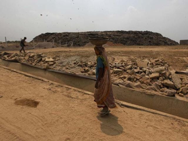 A worker stands on the mud raod to facilitate movement to and from the garbage heaps of Ghazipur Landfill site in east Delhi. Raj K Raj/HT Photos