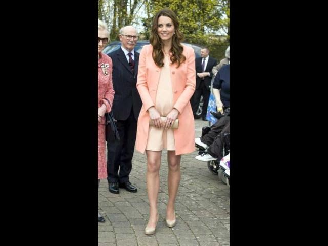 The Duchess seems concious of her bump as she walks around the Naomi House hospice for charity. (AFP Photo)