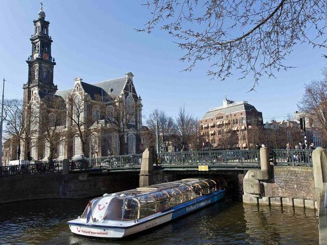 A-tourist-boat-passes-under-a-bridge-next-to-the-Westerkerk-church-in-Amsterdam-Photo-Reuters-Michael-Kooren