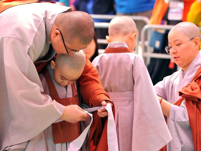 Young South Korean Buddhists are helped with their robes as they attend a ceremony called "children becoming Buddhist monks" at Chogye Temple ahead of Buddha's birthday in central Seoul. AFP