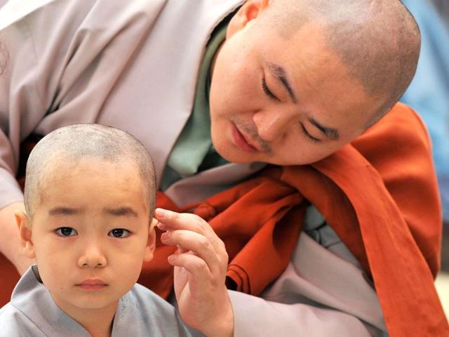 Young South Korean Buddhists with freshly shaved heads line up as they take part in a ceremony called "children becoming Buddhist monks" at Chogye Temple ahead of Buddha's birthday in central Seoul. AFP