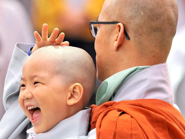 A young South Korean Buddhist boy reacts after have his head shaved during a "children becoming Buddhist monks" ceremony at Chogye Temple in central Seoul. AFP