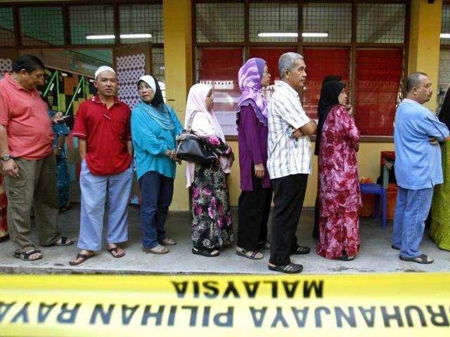 Malaysian voters wait in a line to cast their ballots in the general elections at a polling station in Pekan, Malaysia. AP Photo