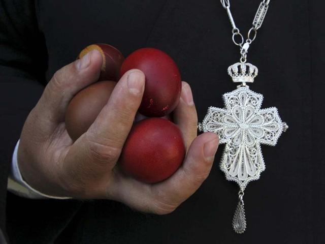 An Orthodox Christian priest holds Easter eggs during an Orthodox Easter mass at Saint Sava church in Mitrovica. Reuters