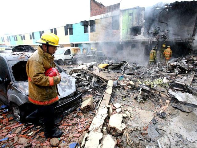 Firefighters extinguish fire at the plane crash scene in Valencia-Carabobo state, Venezula. AFP photo
