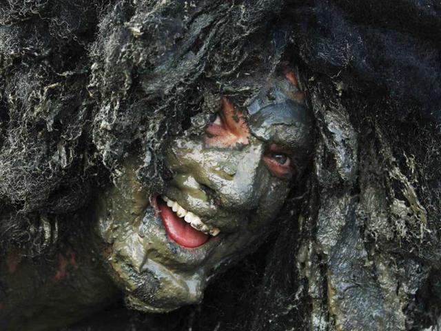 A competitor smiles at the finish of the Maldon Mud Race at the Blackwater River during low tide in Maldon. (Reuters)
