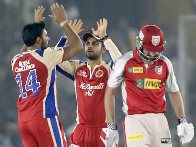 Royal Challengers Bangalore player Virat Kohli celebrates the dismissal Shaun Marsh of Kings XI Punjab's with his teammates during the T20 league match at PCA Stadium in Mohali. PTI