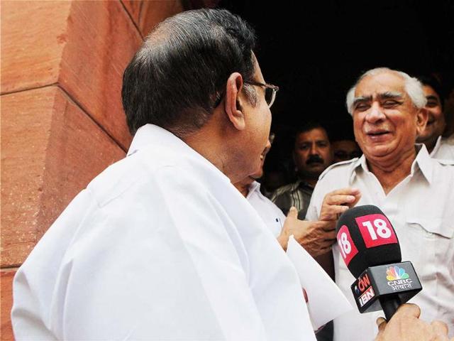 Union finance minister P Chidambaram takes a mike from a TV reporter and poses a question to Jaswant Singh as he emerged from Parliament. (PTI Photo)