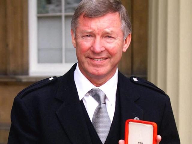 A picture taken on July 20, 1999, shows Manchester United soccer manager Sir Alex Ferguson holds his knighthood insignia that was presented to him by Britain's Queen Elizabeth during an Investiture ceremony at Buckingham Palace, London. (AP)