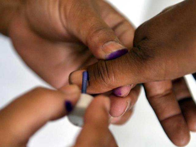 An election poling agent marks ink on a voter's thumb before she cast her vote at a polling station in Islamabad. AFP photo
