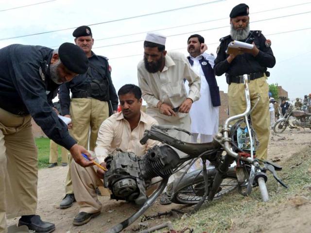 Police officials examine a destroyed motorbike after a bomb explosion in Peshawar. AFP photo
