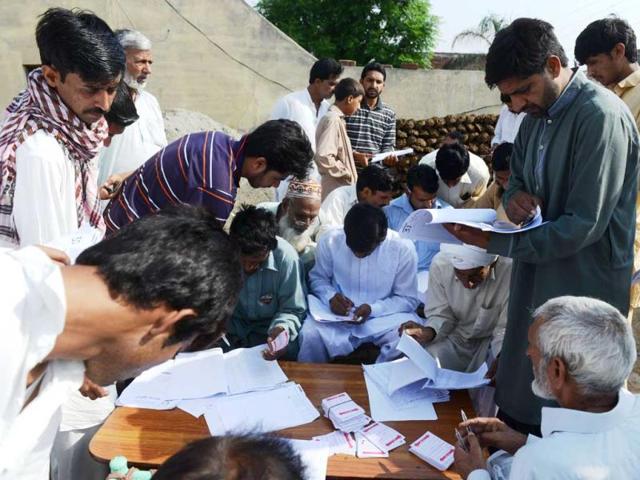 Pakistani residents wanting to vote check voter registration lists near a polling station in the village of Dial on the outskirts of Lahore. AFP photo