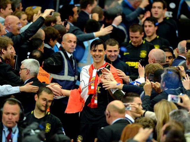 Fans congratulate Wigan Athletic's Austrian midfielder Paul Scharner (C) after his team won the English FA Cup final football match between Manchester City and Wigan Athletic at Wembley Stadium in London. (AFP)