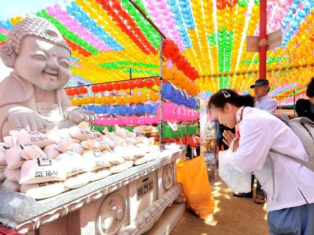 South Korean Buddhist followers pray under rows of lotus lanterns during a ceremony to celebrate the birthday of Buddha at Jogye temple in Seoul. AFP