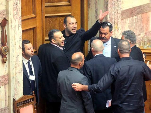 Golden-Dawn-MP-Panagiotis-Iliopoulos-C-gesturing-shouts-in-the-Greek-parliament-as-he-was-ordered-out-by-the-acting-speaker-after-he-poked-fun-at-the-leader-of-the-main-leftist-opposition-Syriza-party-AFP-photo