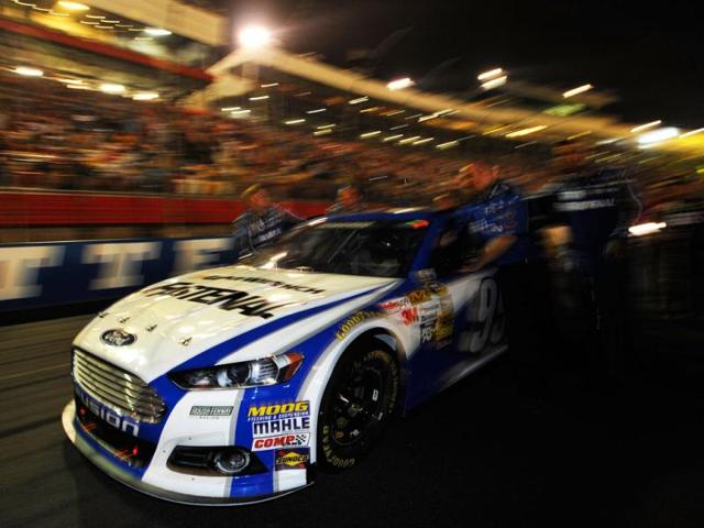 Crew members push the #99 Fastenal Ford of Carl Edwards to the grid prior to the start of the NASCAR Sprint Cup Series All-Star race at Charlotte Motor Speedway in Concord, North Carolina. (AFP Photo)