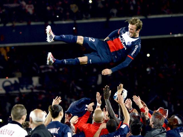 Paris Saint-Germain's English midfielder David Beckham is thrown in the air by teammates after a French L1 football match between Paris St Germain and Brest at Parc des Princes stadium in Paris. (AFP Photo)