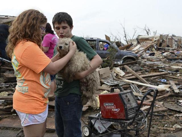 Abby Madi and Peterson Zatterlee comforts Zaterlee's dog Rippy, after a tornado struck Moore, Oklahoma. Reuters