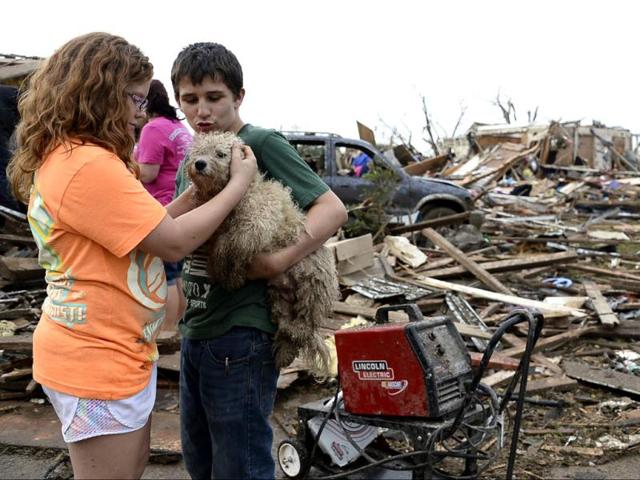 Abby Madi (L) and Peterson Zatterlee comforts Zaterlee's dog Rippy, after a tornado struck Moore, Oklahoma. Reuters photo