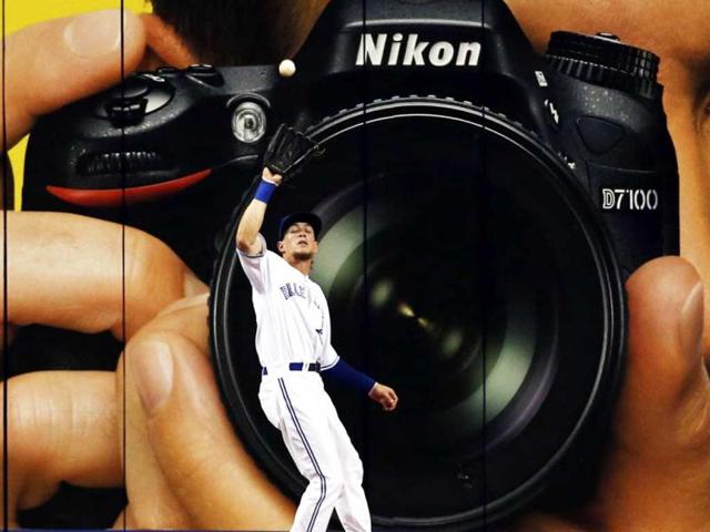 Toronto Blue Jays Colby Rasmus makes a catch against the Tampa Bay Rays in front of a giant camera advertisement during the eighth inning of their MLB American League baseball game in Toronto. Reuters/Mark Blinch