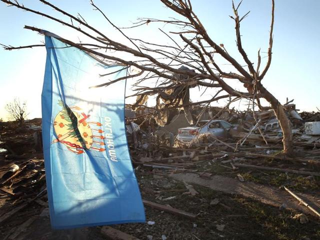 An Oklahoma state flag hangs in a tree next to a destroyed home across the street from the Plaza Towers Elementary School where several children died during a tornado that ripped through the area in Moore, Oklahoma. AFP/Getty Images