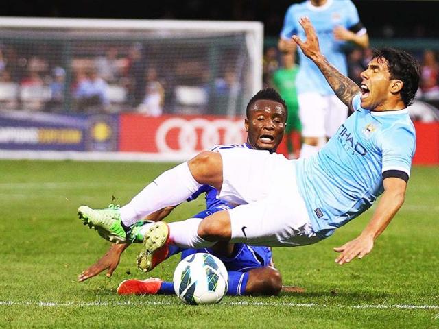 Mikel John Obi of Chelsea trips Carlos Tevez of Manchester City during a friendly match at Busch Stadium, St Louis, Missouri. AFP Photo