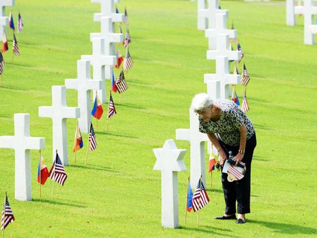 A woman looks at the grave of a soldier who fell during World War II, during services to mark US Memorial Day at the Manila American Cemetery in Fort Bonifacio in Manila. At least 17,000 graves are in the park that pays tribute to US and Philippines soldiers that fought side-by-side during World War II. The US marks Memorial Day on May 27. (AFP)