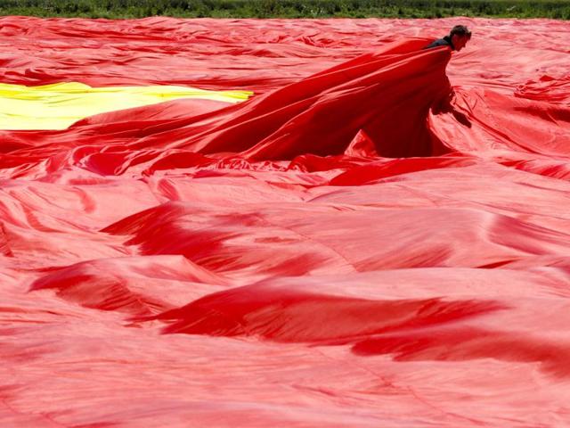 A worker arranges Romania's national flag during a Guinness World Record attempt for the world's biggest national flag in Clinceni. (Reuters)
