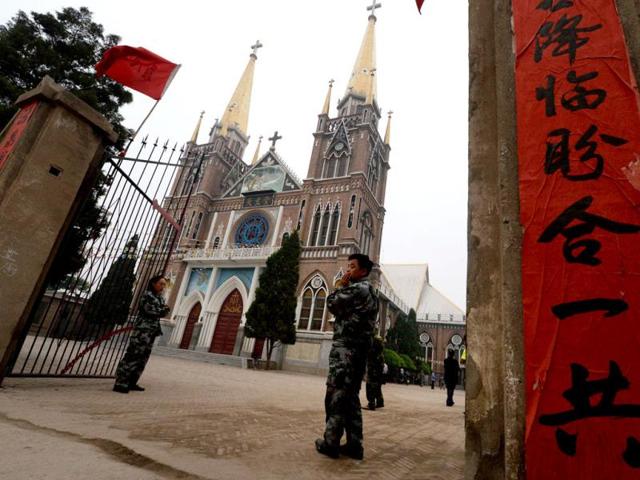 Security guards keep a watch over Chinese Catholics who belong to an "underground" church which is not recognized by the Chinese government, during a mass in Donglu, Hebei Province. AFP photo