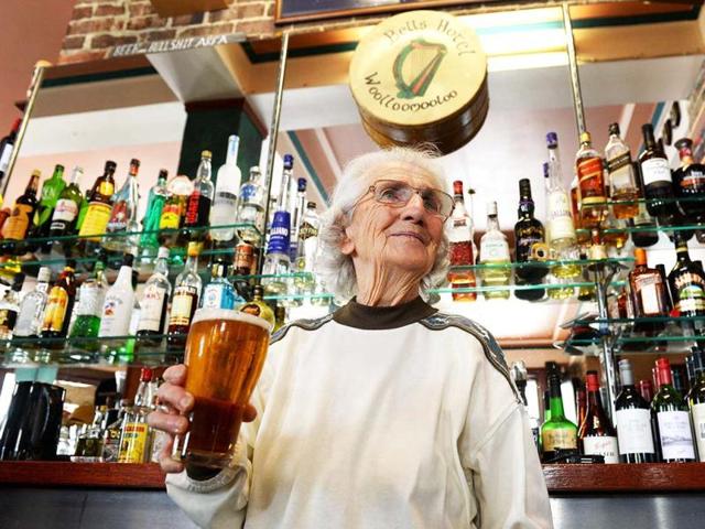 Sydney's oldest barmaid Lil Miles holds a beer at her family's Bells Hotel in Woolloomooloo, Sydney. (AFP)