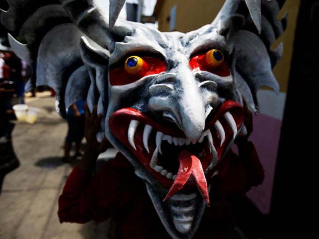 A man holds his devil mask during the Corpus Christi celebrations in San Francisco de Yare, Venezuela. (AP)