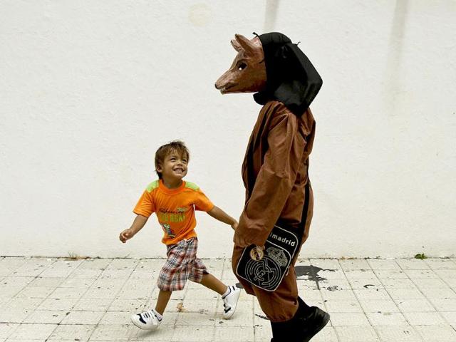 A boy playfully teases another boy dressed in a traditional devil mask and costume during Corpus Christi, a festival celebrating the transformation of the body and blood of Christ into bread and wine, on the streets of La Villa, Panama. (AP)