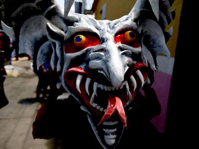 A man holds his devil mask during the Corpus Christi celebrations in San Francisco de Yare, Venezuela. The festival celebrates the transformation of the body and blood of Christ into bread and wine. (AP)