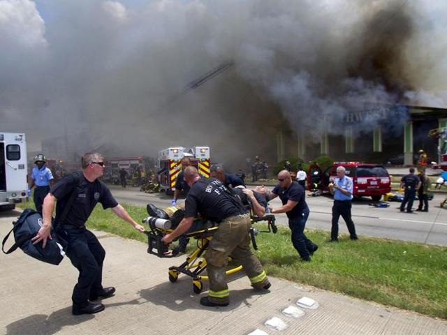 A firefighter is wheeled to an ambulance after fighting a fire at the Southwest Inn in Houston. (AP)