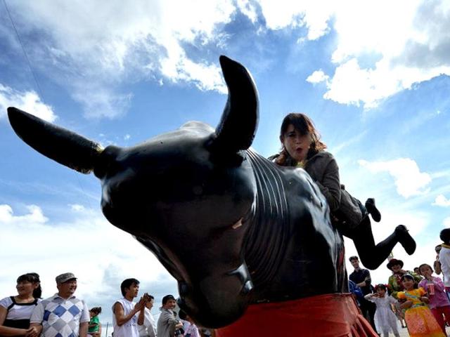A young Mongolian woman rides a mechanical bull at a carnival to celebrate International Children's Day at the Mongolian town of Bayangol. Mongolia, along with current and former Communist countries, celebrates its Children's Day on June 1. (AFP)