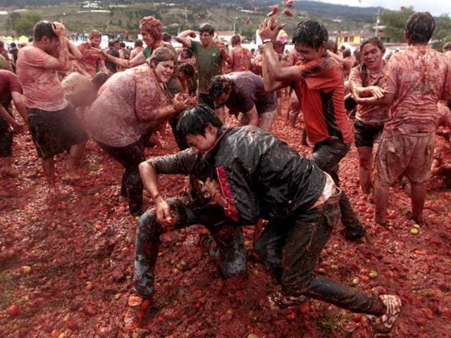 Revellers play with tomato pulp during the annual "Tomatina" (tomato fight) in Sutamarchan province in Boyaca. Reuters/John Vizcaino
