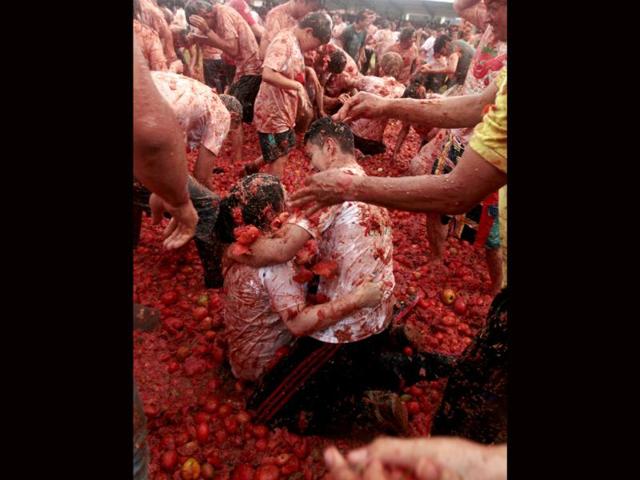 Revellers play with tomato pulp during the annual "Tomatina" (tomato fight) in Sutamarchan province in Boyaca. Reuters/John Vizcaino