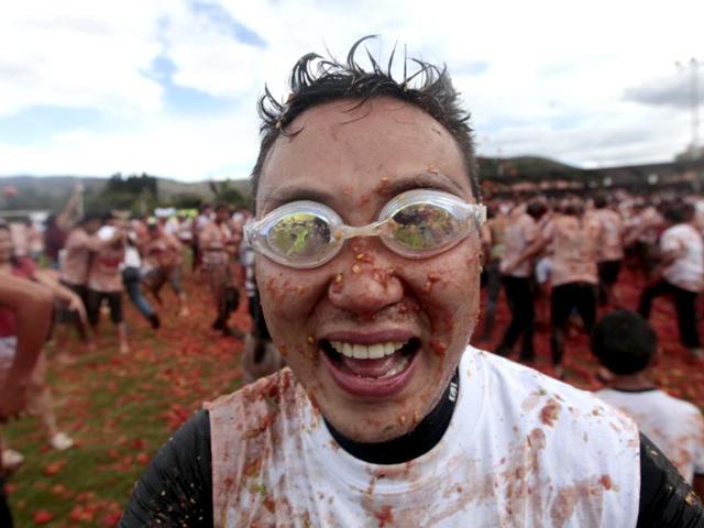A reveller wearing goggles plays with tomato pulp during the annual "Tomatina" (tomato fight) in Sutamarchan province in Boyaca. Reuters/John Vizcaino
