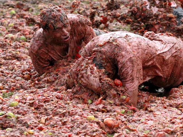 Revellers play with tomato pulp during the annual "Tomatina" (tomato fight) in Sutamarchan province in Boyaca. Reuters/John Vizcaino