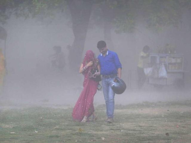 A couple walks through a sandstorm as they enjoy an evening out Delhi. Rain and strong winds lashed the capital, bringing some much needed relief to the people. (AP)