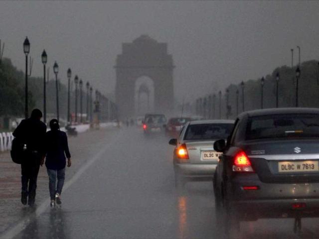 A couple walks along Rajpath near India Gate as rain brought Delhi some much needed respite from rising temperatures. (PTI)