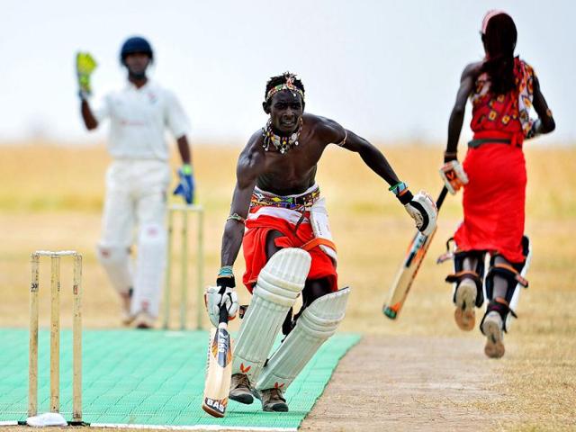 A Maasai batsman scores runs as the Maasai Warriors cricket team play a Twenty twenty match against international cricket team the Abassadors, in Ol Pejeta conservency in Laikipia national park. AFP PHOTO