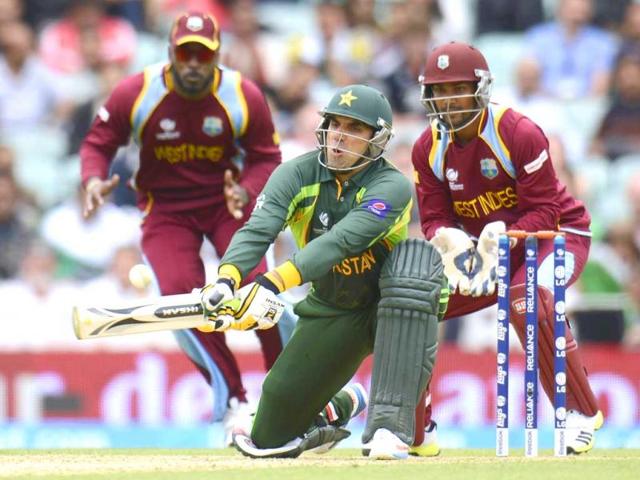 Misbah-Ul-Haq plays a reverse sweep as West Indies' Chris Gayle and Denesh Ramdin (R) look on during the ICC Champions Trophy group B match at The Oval cricket ground in London. (Reuters)