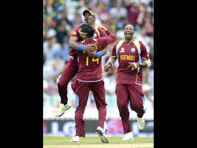 Dwayne Bravo leaps on teammate Sunil Narine as Kieron Pollard (R) looks on after the dismissal of Pakistan's Kamran Akmal during the ICC Champions Trophy group B match at The Oval cricket ground, London. (Reuters)